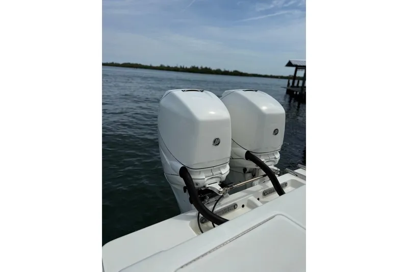 Slide: The Image of Twin outboard engines on a 2014 SeaVee 290B boat, docked by the water. - 7