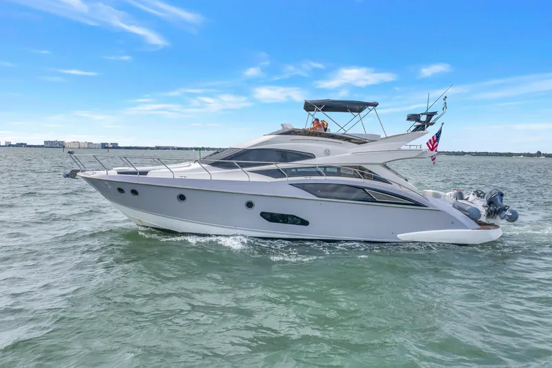 The Image of 2009 Marquis 500 Sport Bridge yacht cruising on open water under a clear blue sky. - 0