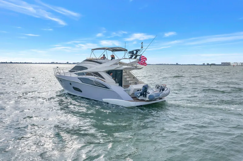 Slide: The Image of 2009 Marquis 500 Sport Bridge yacht cruising on open water under a clear blue sky. - 1