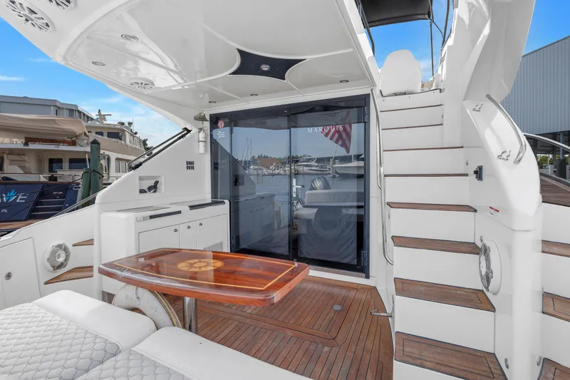 Slide: The Image of 2009 Marquis 500 Sport Bridge yacht deck with seating, table, and stairs. - 16