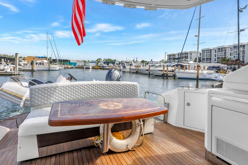 Slide: The Image of 2009 Marquis 500 Sport Bridge yacht interior with elegant seating and table, docked at marina. - 18
