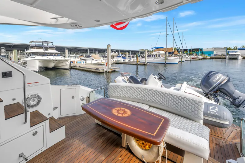 Slide: The Image of 2009 Marquis 500 Sport Bridge yacht deck with Zodiac boat and Yamaha motor at marina. - 19