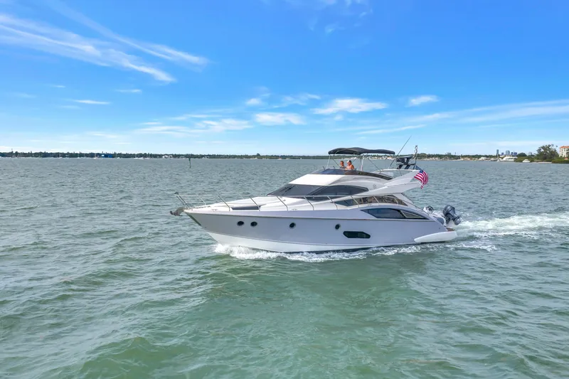 Slide: The Image of 2009 Marquis 500 Sport Bridge yacht cruising on open water under clear blue skies. - 2