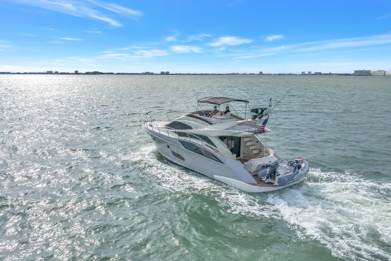 Slide: The Image of 2009 Marquis 500 Sport Bridge yacht cruising on open water under clear blue skies. - 3