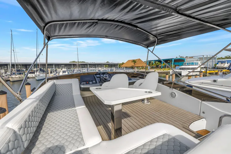 Slide: The Image of 2009 Marquis 500 Sport Bridge yacht interior with seating and table, docked at marina. - 31