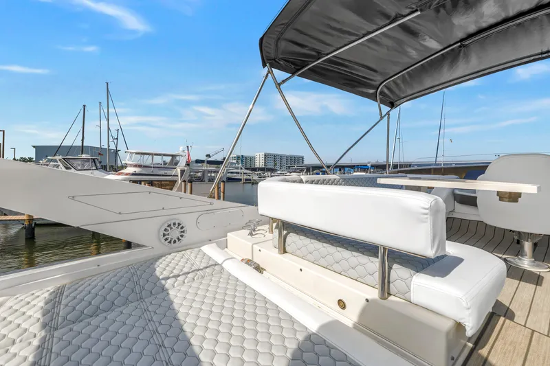 Slide: The Image of Luxurious 2009 Marquis 500 Sport Bridge yacht with elegant seating and canopy at marina. - 34