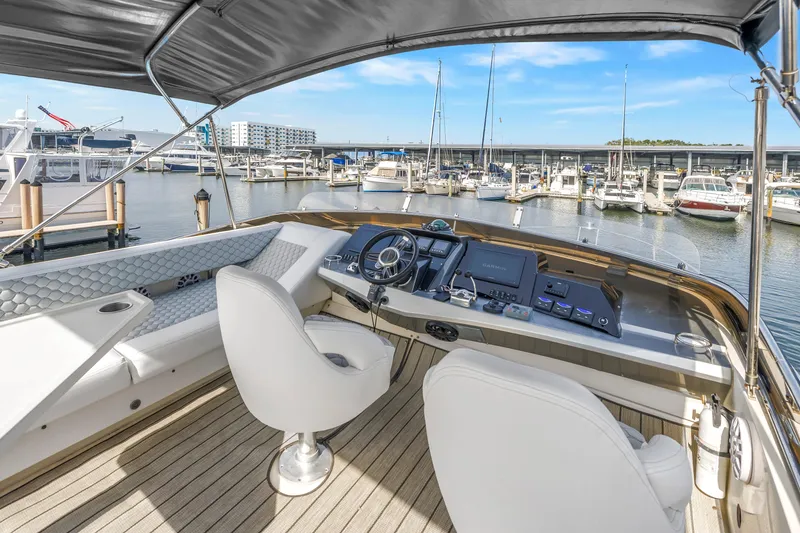 Slide: The Image of 2009 Marquis 500 Sport Bridge yacht helm with marina view, featuring modern controls and seating. - 39