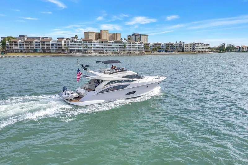 Slide: The Image of 2009 Marquis 500 Sport Bridge yacht cruising near waterfront buildings. - 4