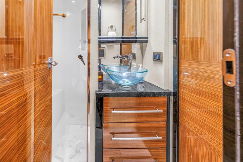 Slide: The Image of Luxurious bathroom interior of 2009 Marquis 500 Sport Bridge yacht with glass sink and wooden cabinetry. - 51