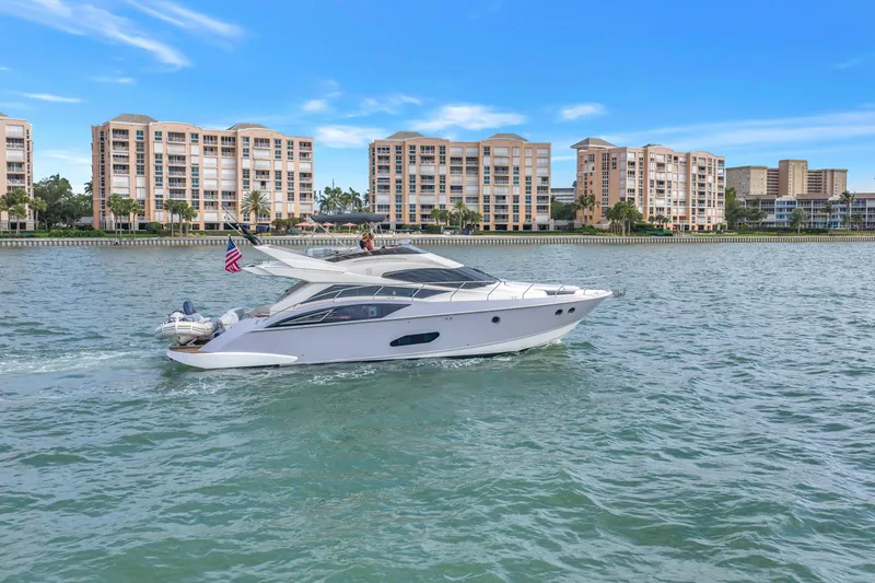Slide: The Image of Luxury 2009 Marquis 500 Sport Bridge yacht cruising near waterfront condos. - 6