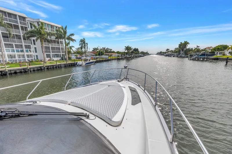 Slide: The Image of 2009 Marquis 500 Sport Bridge yacht cruising on a scenic canal with palm trees. - 9