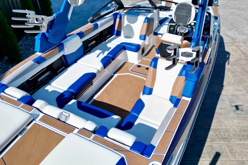 Slide: The Image of 2022 Malibu M240 boat interior with blue and white seating, brown accents, and modern design. - 14