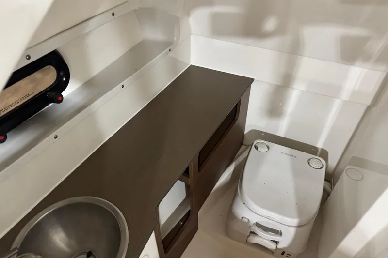 Slide: The Image of Interior of 2018 Sea Ray SDX 270 boat featuring a compact bathroom with sink and toilet. - 12