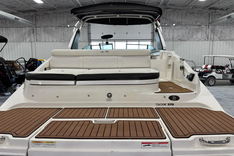 Slide: The Image of 2018 Sea Ray SDX 270 boat interior with teak flooring and cushioned seating. - 7