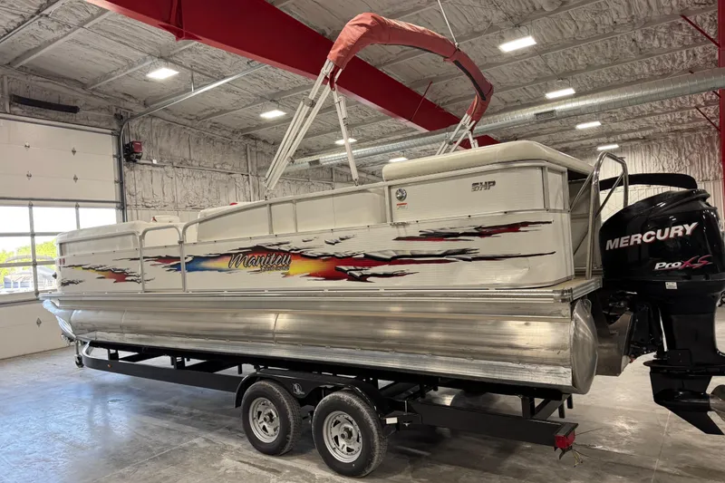 Slide: The Image of 2010 Manitou 25 X-Plode pontoon boat with Mercury Pro XS engine in a warehouse. - 4