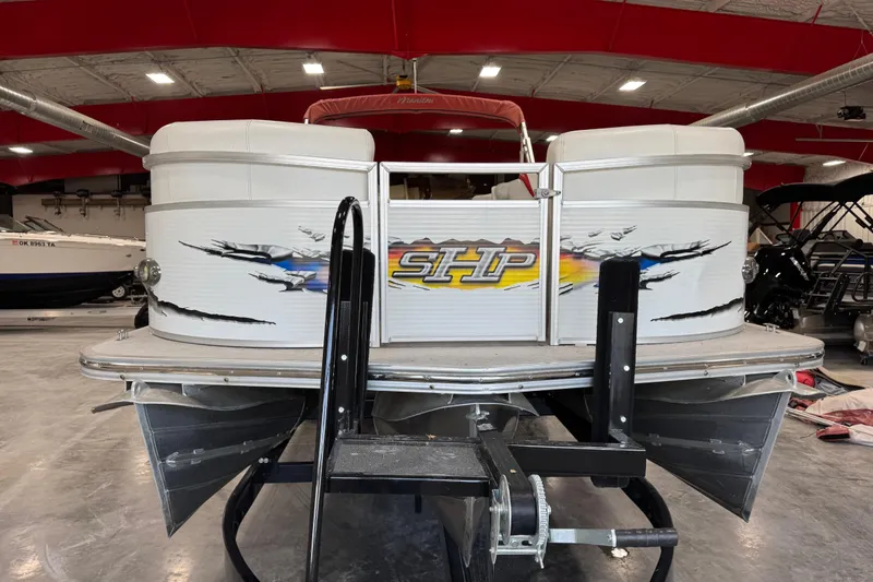 Slide: The Image of 2010 Manitou 25 X-Plode pontoon boat in a showroom, featuring bold graphics and sturdy design. - 7