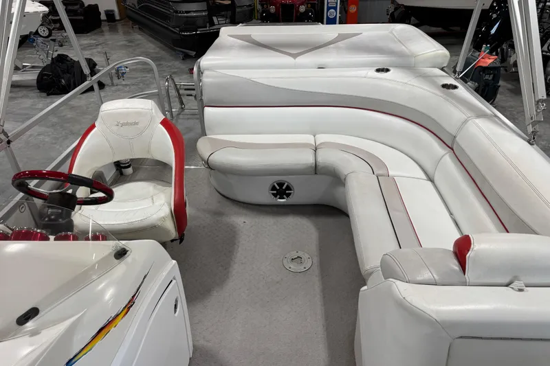 Slide: The Image of Interior of a 2010 Manitou 25 X-Plode boat with white and red seating. - 8