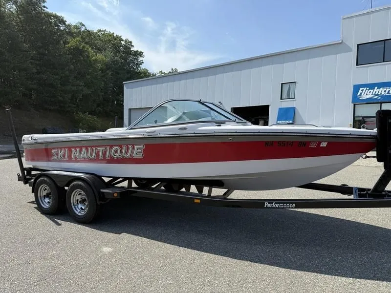 Slide: The Image of 2008 Nautique Ski Nautique 206 boat on trailer in front of building. - 2