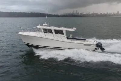 The Image of 2018 Ocean Sport 33 Roamer cruising on a calm sea with city skyline in background. - 1