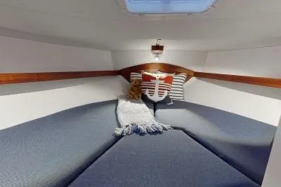 Slide: The Image of 2018 Ocean Sport 33 Roamer cabin with cozy bedding and nautical-themed pillows. - 12