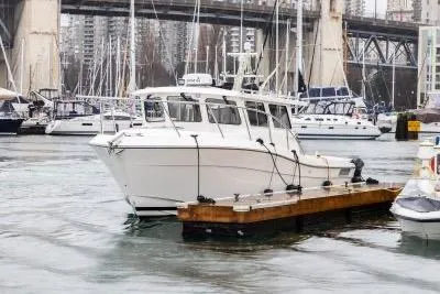 Slide: The Image of 2018 Ocean Sport 33 Roamer docked in a marina with cityscape background. - 13