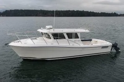 Slide: The Image of 2018 Ocean Sport 33 Roamer boat on calm water, overcast sky in the background. - 3