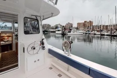 Slide: The Image of 2018 Ocean Sport 33 Roamer docked at marina with cityscape background. - 5