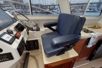 Slide: The Image of 2018 Ocean Sport 33 Roamer helm with blue captain's chair and navigation controls. - 8