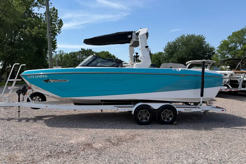 The Image of 2023 Nautique Super Air Nautique G25 boat on trailer, turquoise and white design. - 1
