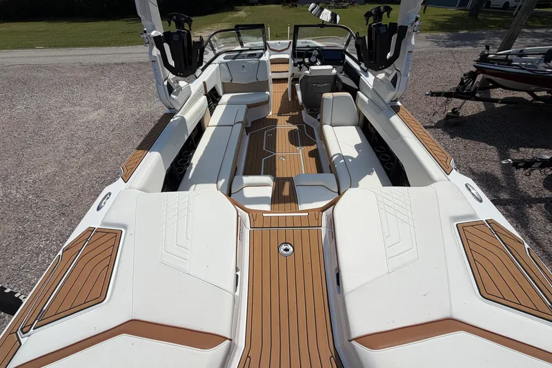 Slide: The Image of 2023 Nautique Super Air Nautique G25 interior with luxurious seating and teak flooring. - 12