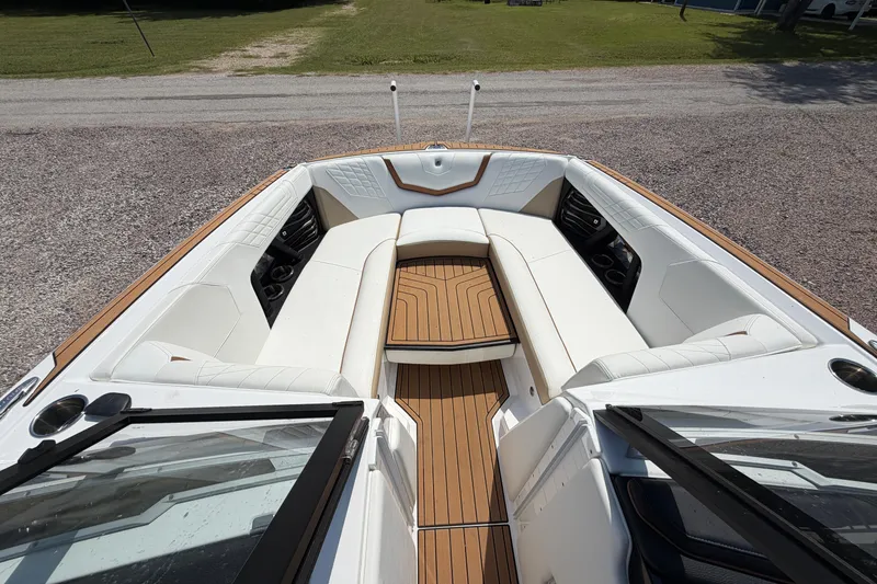 Slide: The Image of 2023 Nautique Super Air Nautique G25 boat interior with white seating and teak flooring. - 16