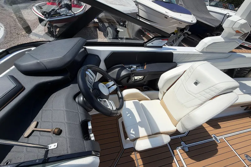 Slide: The Image of 2023 Nautique Super Air Nautique G25 cockpit with luxurious seating and modern steering wheel. - 19