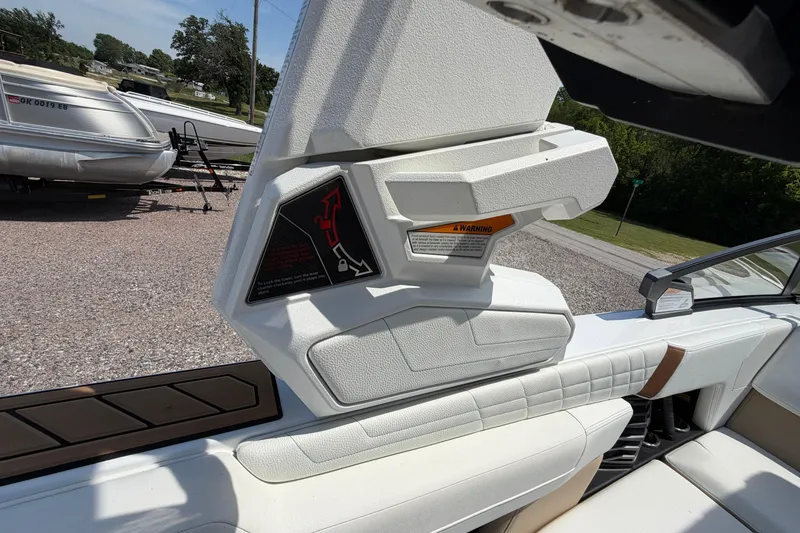 Slide: The Image of 2023 Nautique Super Air Nautique G25 interior detail with white upholstery and safety instructions. - 20