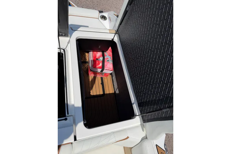 Slide: The Image of Storage compartment of 2023 Nautique Super Air Nautique G25 with a red bag inside. - 22