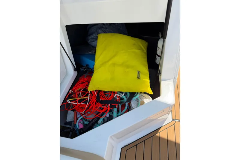 Slide: The Image of Storage compartment of 2023 Nautique Super Air Nautique G25 with ropes and yellow bag. - 25