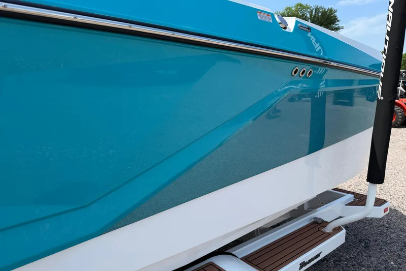 Slide: The Image of 2023 Nautique Super Air Nautique G25 boat, blue and white hull, side view. - 5
