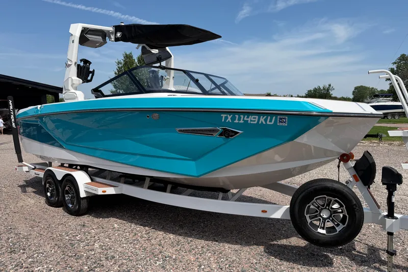 Slide: The Image of 2023 Nautique Super Air Nautique G25 boat on trailer, vibrant blue and white design. - 7