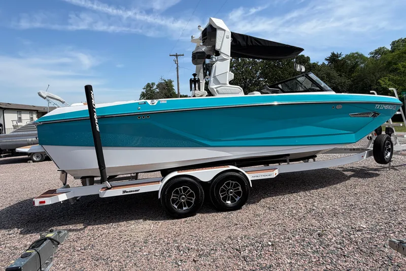 Slide: The Image of 2023 Nautique Super Air Nautique G25 boat on trailer, vibrant blue color, parked outdoors. - 8