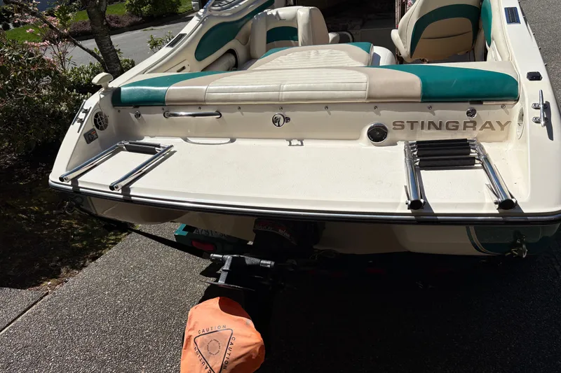 Slide: The Image of 1997 Stingray 200 CS boat with teal and white seating, rear view. - 18