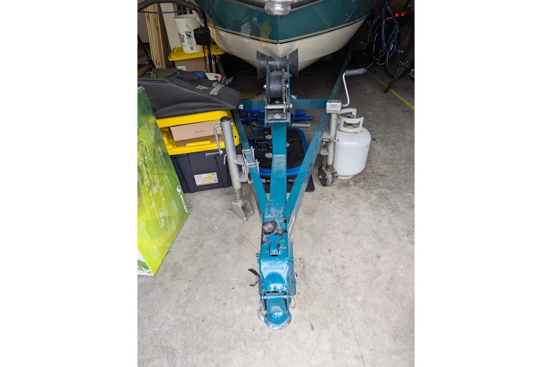 Slide: The Image of 1997 Stingray 200 CS boat trailer in garage with storage items and propane tank. - 26