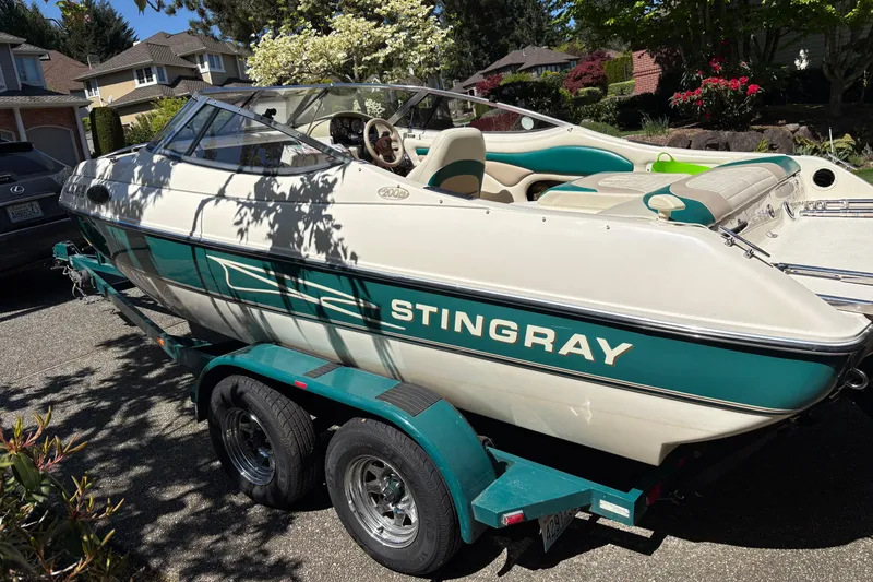 Slide: The Image of 1997 Stingray 200 CS boat on trailer, parked in residential area. - 3