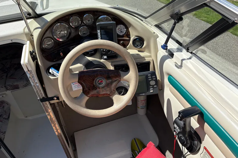 Slide: The Image of Interior view of a 1997 Stingray 200 CS boat dashboard with steering wheel and controls. - 9