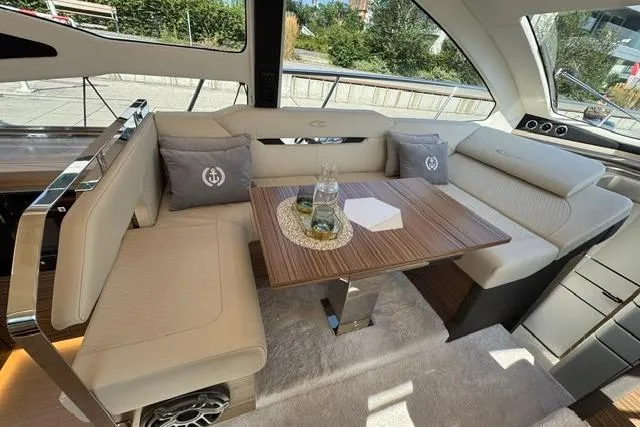 Slide: The Image of Luxurious interior of 2026 Cobrey 45 FLY yacht with elegant seating and wooden table. - 12