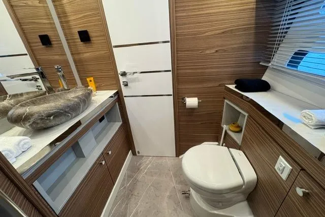 Slide: The Image of Luxurious bathroom in 2026 Cobrey 45 FLY yacht with modern fixtures and wood accents. - 21