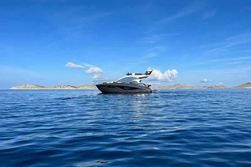 Slide: The Image of 2026 Cobrey 45 FLY yacht cruising on serene blue waters under a clear sky. - 4