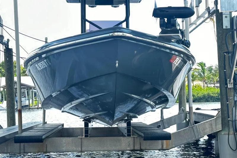 Slide: The Image of 2024 H-Craft 27 CC boat on lift, docked by waterfront, showcasing sleek hull design. - 10
