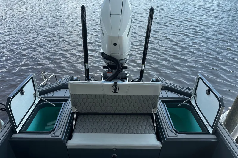 Slide: The Image of 2024 H-Craft 27 CC boat with open storage compartments and powerful outboard motor on water. - 13