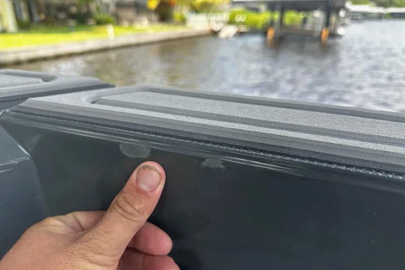 Slide: The Image of Close-up of 2024 H-Craft 27 CC boat detail with hand inspecting surface. - 20