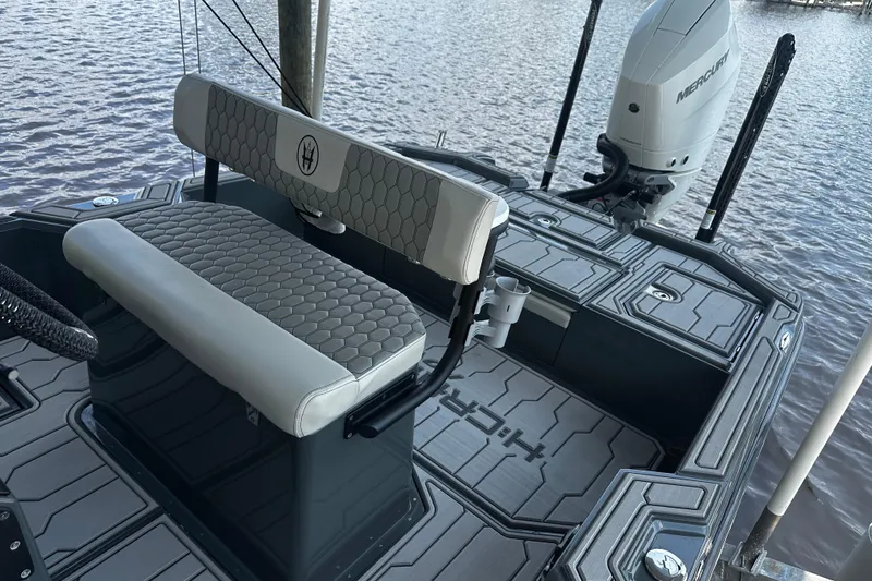 Slide: The Image of 2024 H-Craft 27 CC boat interior with seating and Mercury engine by the water. - 21