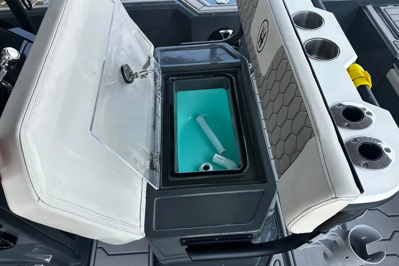 Slide: The Image of Open storage compartment on 2024 H-Craft 27 CC boat with cup holders and cushioned seating. - 22